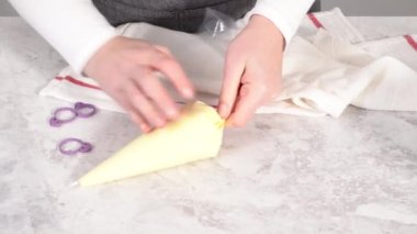 Adım adım. Tek boynuzlu at meringue kurabiyesi pişirmek için metal uçlu boru torbalarına krema karıştırılıyor..