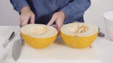 Zaman aşımı. Adım adım. Beyaz kesme tahtasında kaygan altın çiğ taneli kavun.