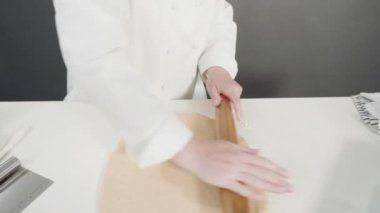 Tarçınlı rulo yapmak için Fransız merdanesiyle yuvarlanan hamurlar..