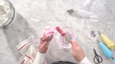 Düz yatıyordu. Adım adım. Tek boynuzlu at meringue kurabiyesi pişirmek için metal uçlu boru torbalarına krema karıştırılıyor..