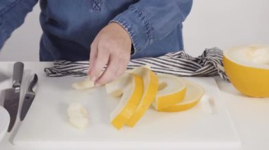 Adım adım. Beyaz kesme tahtasında kaygan altın çiğ taneli kavun.