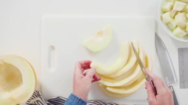 Düz yatıyordu. Beyaz kesme tahtasında kaygan altın çiğ taneli kavun.