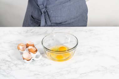 Büyük bir bardakta ıslak malzemeler karıştırarak kırmızı kadife kekler ve beyaz çikolatalı ganache kreması pişiriyorum..