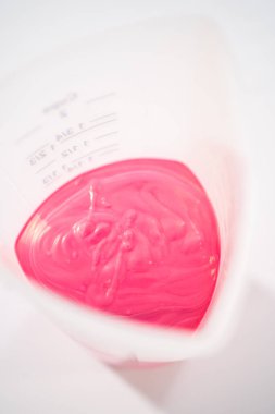 Sevgililer Günü 'nde çikolata kaplı çubuk çubuk kraker yapmak için silikon bardakta erimiş çikolata parçaları..