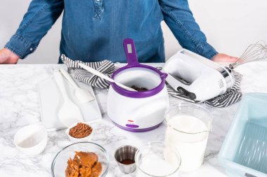 Çikolatalı dondurma yapmak için bardaktaki malzemeleri karıştırıyorum..