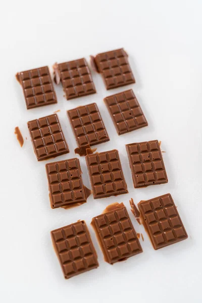 Silikon Çikolata Kalıbından Küçük Çikolataları Alıp Beyaz Bir Kesme Tahtasına — Stok fotoğraf