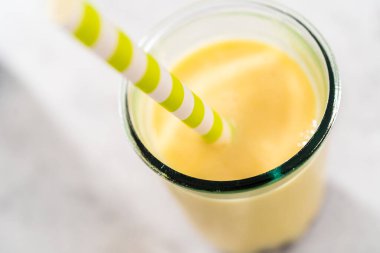 Taze yapılmış mango boba smoothie. Kağıt kamışla içme bardağında..