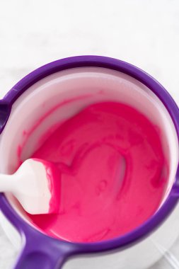 Çikolata erir, şeker tenceresinde erir. Gurme mini çikolatalar hazırlamak için çikolata serpiştirir..