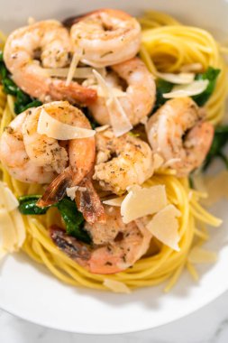 Beyaz seramik kaselerde ıspanaklı sarımsaklı karides makarnası servis ediyorum..