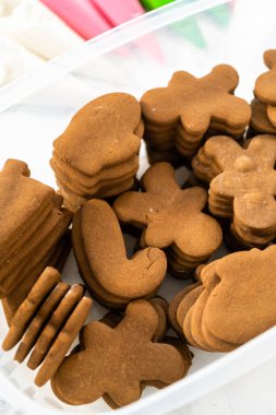 Süslenmemiş zencefilli kurabiye yığınları kraliyet kreması ile süslenmeye hazır..