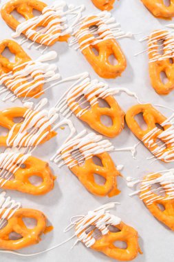 Çikolata soslu krakerlerin üzerine erimiş çikolata serpiştirmek..