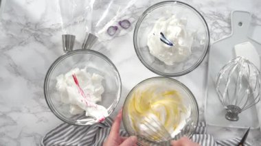 Adım adım. Düz yatıyordu. Tek boynuzlu at kurabiyesi pişirmek için besin boyasını kremaya karıştırıyorum..