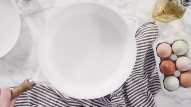 Düz yatıyordu. Beyaz tavada taze yumurta kızartıyorlar..