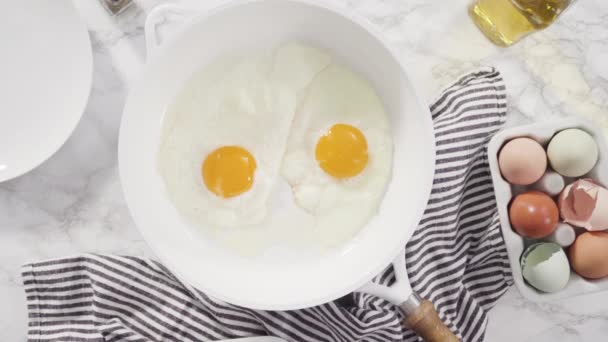 平置きだ 白いフライパンで新鮮な卵を炒める — ストック動画