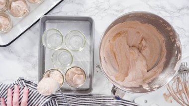 Düz yatıyordu. Adım adım. Ev yapımı çikolatalı dondurmayı cam kavanozlara koymak..