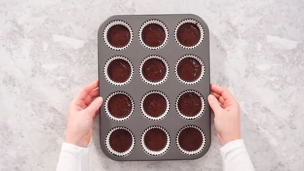 stock image Flat lay. Step by step. Scooping chocolate cupcake dough into the cupcake liners.