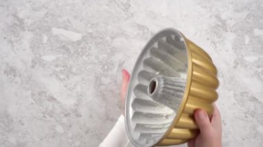Düz yatıyordu. Adım adım. Bitkisel kısaltmalı ve beyaz un serpiştirilmiş yağlı kek tavası..