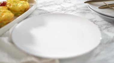 Adım adım. Beyaz tabakta dilimlenmiş pastırma ve peynirli kek..