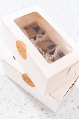 Fıstık ezmeli ev yapımı çikolatalı şekerlemeler beyaz bir hediye kutusuna konuyor..