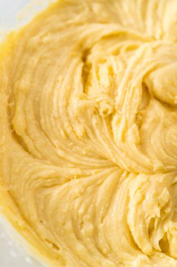 Limonlu yaban mersinli kek yapmak için büyük bir bardakta karıştırma malzemesi..