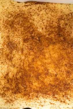 Kare bir peynirli kek pişirme tavasında parşömen kağıdıyla kaplanmış taze yapılmış ev yapımı yumurta likörü..