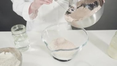 Zaman aşımı. Tarçınlı rulo pişirmek için cam bir kasenin içindekileri ölçüyorum..