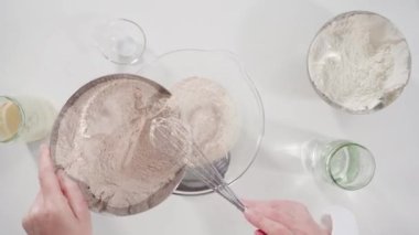 Time lapse. Flat lay. Measuring ingredients into a glass bowl to bake cinnamon rolls.
