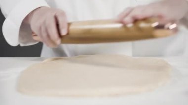 Tarçınlı rulo yapmak için Fransız merdanesiyle yuvarlanan hamurlar..