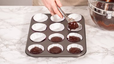 Step by step. Baking chocolate cupcakes. Scooping chocolate cupcake batter into a cupcake pan.