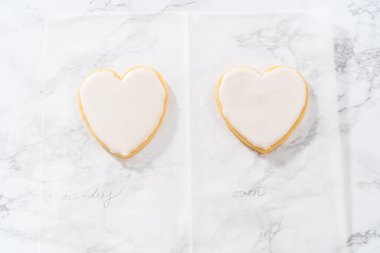 Sevgililer Günü için pembe ve beyaz kraliyet kremalı kalp şeklinde kurabiyeler..