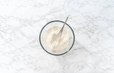 Düz yatıyordu. Limon jöleli limonlu kurabiye. Limonlu kurabiye pişirmek için büyük bir bardakta kurutulmuş malzemeleri çırpma kabıyla karıştırıyorum..