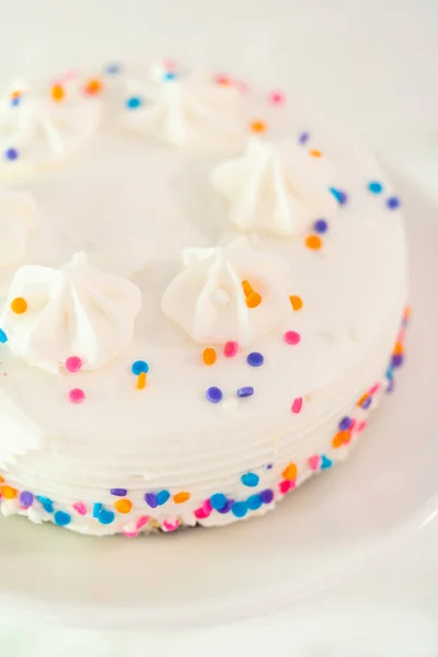 白いケーキプレート上にFunettiスプリンクル付き白い小さな誕生日ケーキ — ストック写真