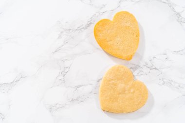 Sevgililer Günü için pembe ve beyaz kraliyet kremalı kalp şeklinde kurabiyeler..