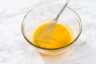 Limon jöleli limonlu kurabiye. Islak malzemeleri büyük bir bardakta karıştırıp limonlu kurabiye pişirmek için karıştırıyorum..