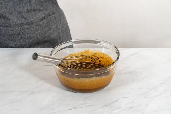 将湿配料倒入一个小玻璃杯搅拌碗中 将姜饼包在焦糖中烘焙 — 图库照片