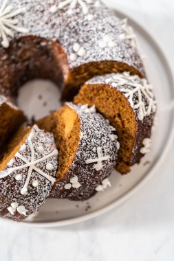 Dilimlenmiş zencefilli kek karamel dolgulu, kremalı pasta ve kek tabağında toz şeker..