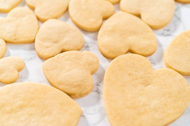 Sevgililer Günü için pembe ve beyaz kraliyet kremalı kalp şeklinde kurabiyeler..