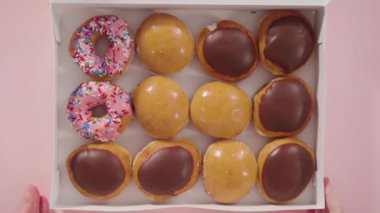 Düz yatıyordu. Beyaz bir karton kutuda mağazadan alınmış donutların çeşitliliği.