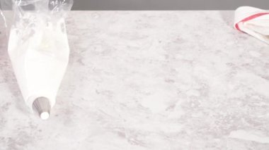 Adım adım. Tek boynuzlu at meringue kurabiyesi pişirmek için metal uçlu boru torbalarına krema karıştırılıyor..