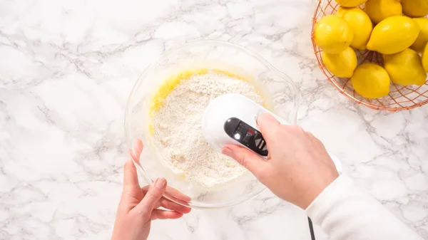 stock image Flat lay. Step by step. Mixing ingredients in a glass mixing bowl to prepare lemon bundt cake.