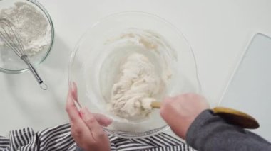 Düz yatıyordu. Ev yapımı ekmek yapmak için karıştırma kabının içindeki malzemeleri karıştırıyorum..