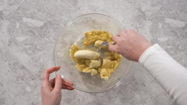 ココナッツバナナパンケーキを準備するためにガラス混合ボウルに揚げバナナを粉砕 — ストック動画