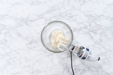 Düz yatıyordu. Marketten alınmış vanilyalı şekerlemeyi cam bir kaseyle karıştırıyorum..