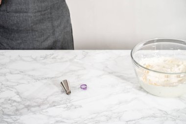 Naneli kremayı hazırlamak için cam bardakta tereyağı çırpma kreması karıştırma kabıyla elektrikli el mikseri..