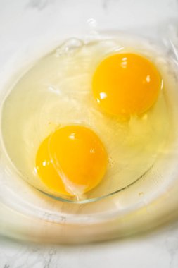 Büyük bir bardaktaki malzemeleri karıştırarak naneli çikolatalı kekler pişiriyorum..