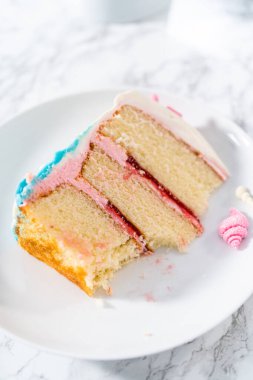 Deniz kızı temalı 3 katlı vanilyalı pasta dilimi. Çikolatalı deniz kızı kuyruğu ve beyaz tabakta deniz kabukları..