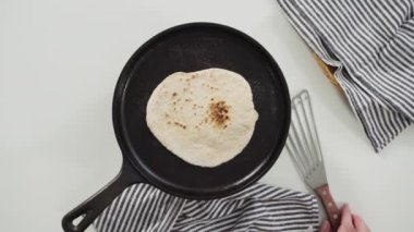 Düz yatıyordu. Dökme demir tavada ev yapımı ekmek hazırlıyorum..