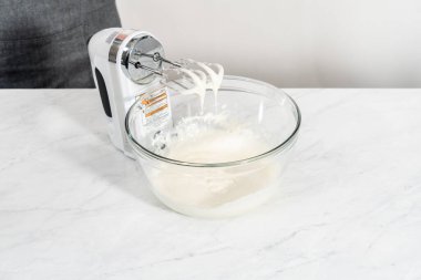Krem peyniri jöleli yapmak için karışımı büyük bir bardakta karıştırıyorum..