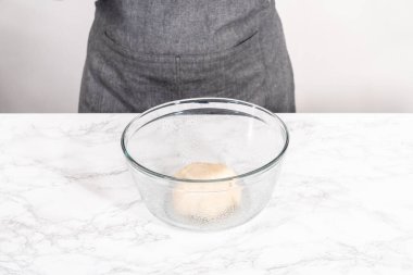 Tarçınlı tatlı pizzası hazırlamak için cam bir kasede pizza hamuru yetiştiriyorum..