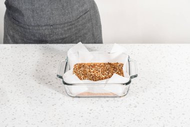 Kabak aromalı şekerleme hazırlamak için parşömen kağıdıyla kaplanmış kare cam fırın tavasına şekerleme dökülüyor..